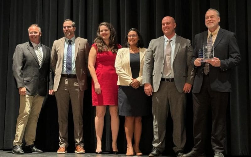 This image shows elected, appointed, and professional representatives holding an award.