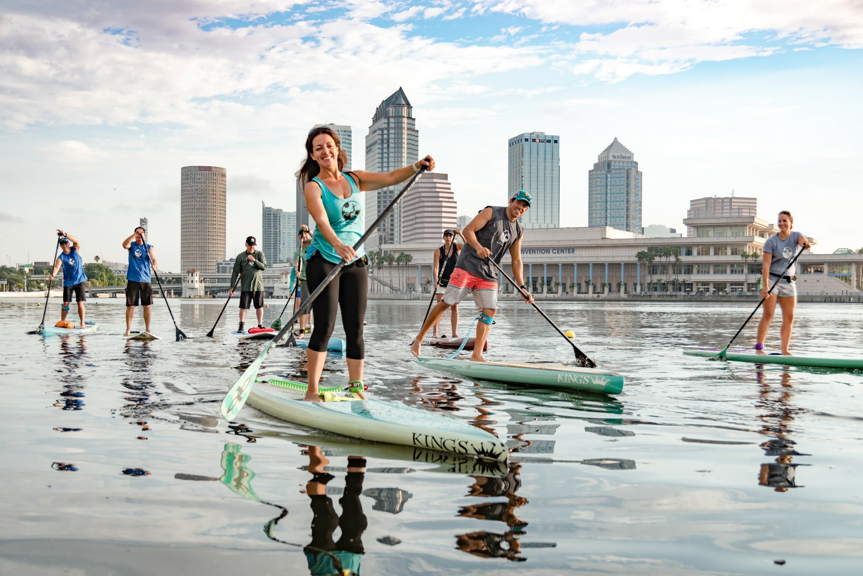 A group of people riding standup paddle boards in Tampa Bay
